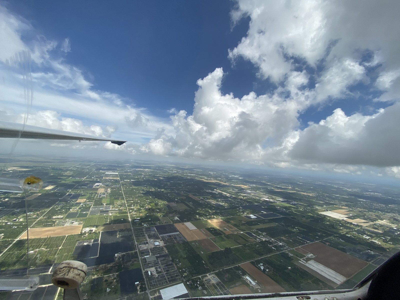 Wing over the Everglades and South Florida farmland &mdash; view from the cockpit