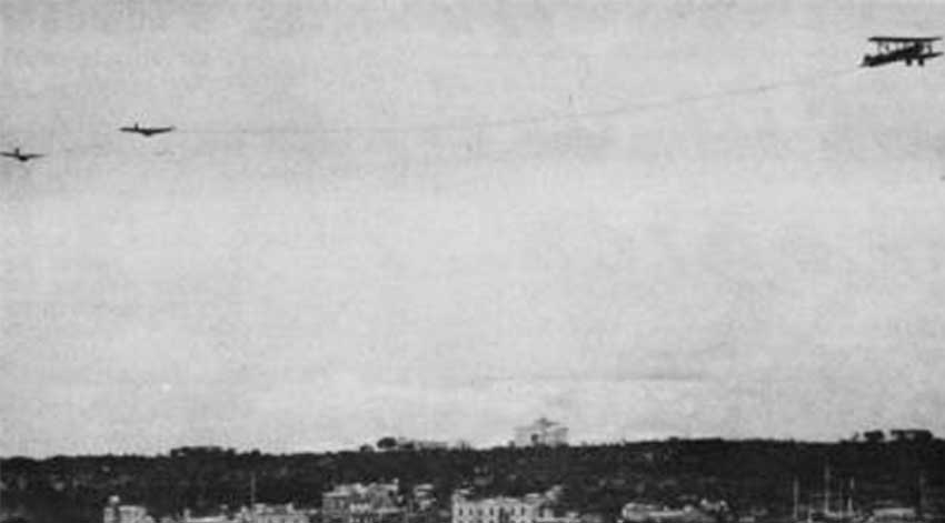 Period press photo of the 1935 sky train: a biplane towing two Franklin PS-2 sailplanes over the Havana skyline just before release over the Capitolio