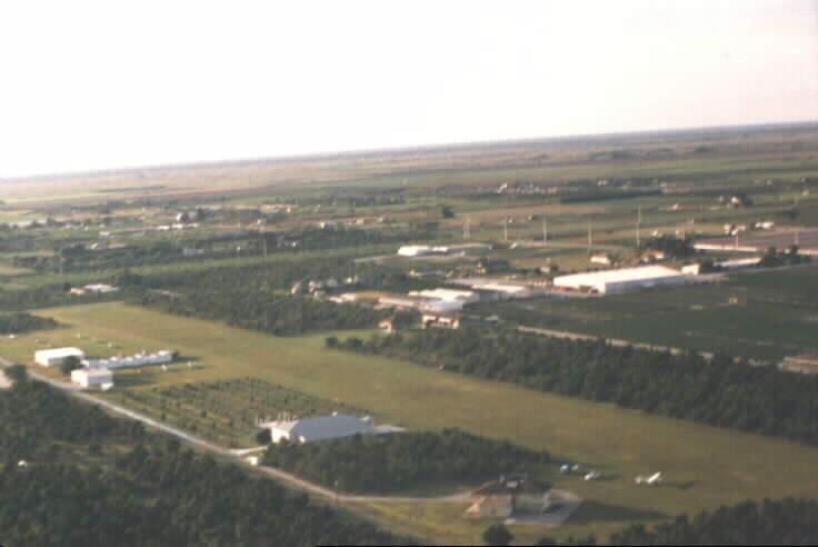 Aerial view of Richard's Field, August 2001: small grass airstrip with hangars and sailplanes, surrounded by South Florida farm fields and orchards