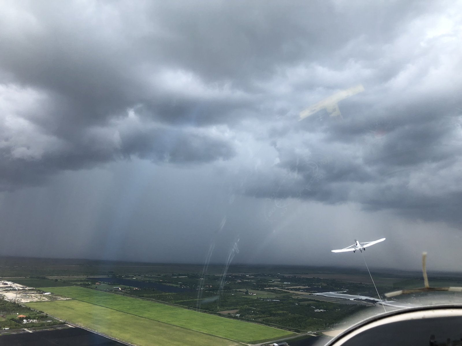 Towplane in flight near a tropical storm cell over South Florida